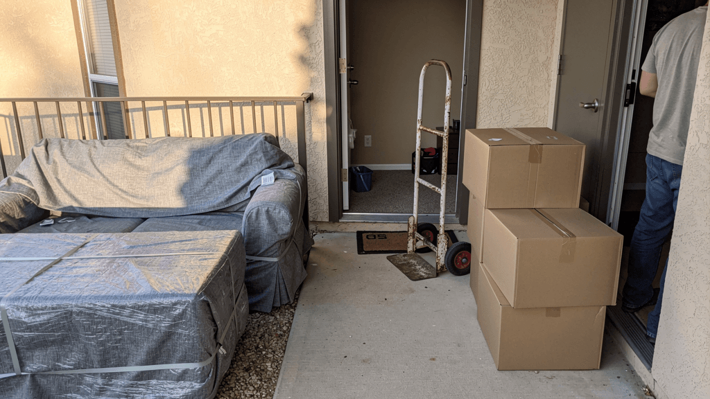 Wrapped apartment furniture and moving equipment near a College Hills walkway