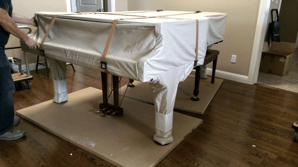 Movers protecting a baby grand piano for a San Angelo piano move