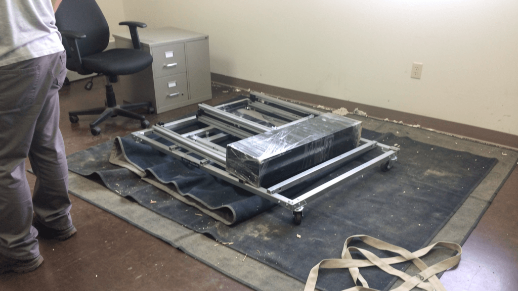 Office equipment and wrapped workplace furniture staged for a San Angelo commercial move